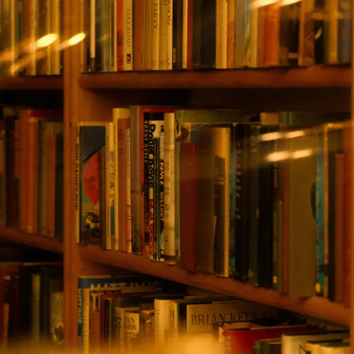 estante de livros iluminada representando como publicar um livro pela Amazon